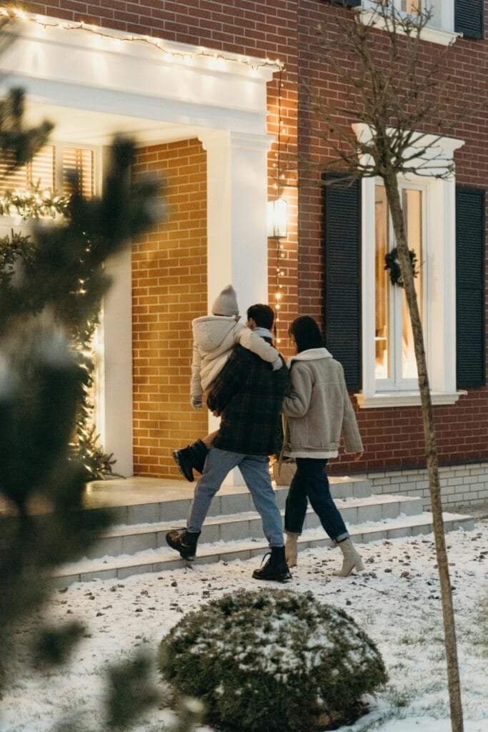 pexels-photo-6276187-6276187 A family walks into their home on a snowy Christmas Eve, creating a warm holiday atmosphere.